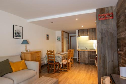 un salon et une cuisine avec un canapé et une table dans l'établissement Tignes - Appartement vue golf, à Tignes