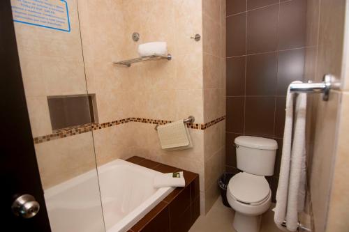 a bathroom with a tub and a toilet and a shower at Playa Caracol Hotel & Spa in Veracruz