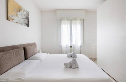 a white bedroom with a large bed with towels on it at Formigine - [Motor Valley-Homes] in Formigine