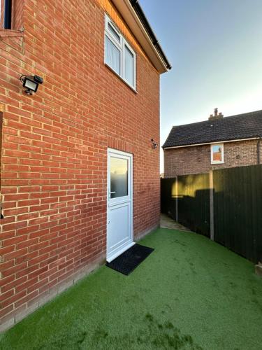 a brick building with a white door in a yard at Double Room With Free WiFi Keedonwood Road in Bromley