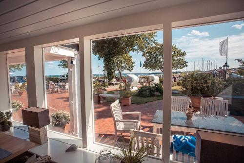 a screened in porch with a view of a patio at Strandhotel Strande in Strande