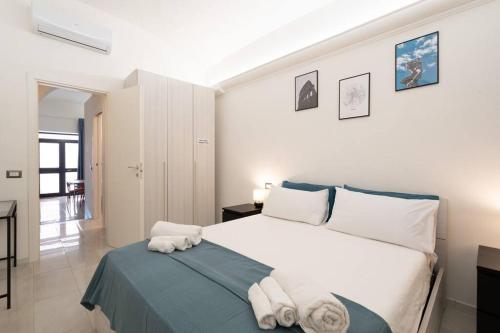 Un dormitorio con una cama blanca con toallas. en San Lorenzo [10 min Colosseum taking M Manzoni] en Roma