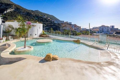 une grande piscine avec un arbre au milieu dans l'établissement Hidden Gem at Luxurious Ocean Village, à Gibraltar