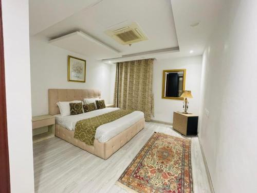 ein Hotelzimmer mit einem Bett und einem Teppich in der Unterkunft Luxury one bed Apartment in Gold Crest Mall And Residency DHA Lahore in Lahore