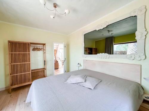 een slaapkamer met een wit bed en een grote spiegel bij Casa Bagus in Lajares
