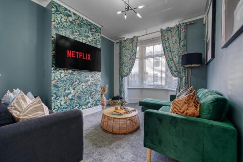 a living room with two green chairs and a table at Stunning Design 3-Bedroom Townhouse Retreat in Southsea, Sleeps 8, Chic and Spacious with Free Parking Permit, SPRING SPECIAL OFFER AVAILABLE! - by Blue Puffin Stays in Portsmouth