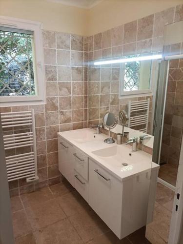une salle de bain avec un lavabo blanc et un miroir dans l'établissement Villa Les Vignes, à Flayosc