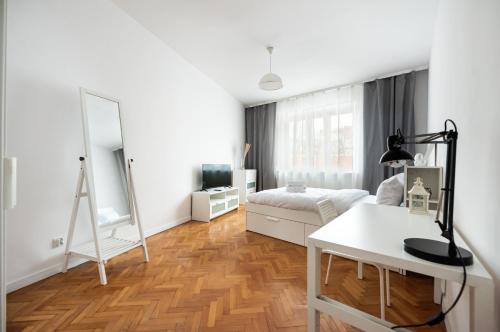 ein weißes Wohnzimmer mit einem Bett und einem Spiegel in der Unterkunft Old Town 5-Bedroom Apartment in Warschau