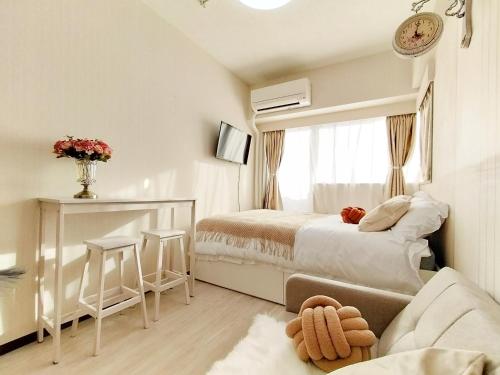 a white bedroom with a bed and a window at Z87新宿最中心 東新宿站5分-Shinjuku center 5 mins to Station, Max 3P 新宿 涉谷 表参道 池袋 上野 代代木 银座 原宿 in Tokyo