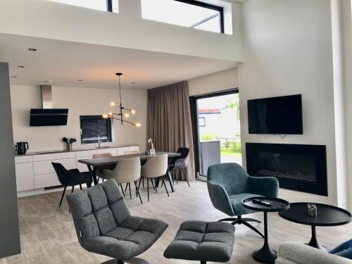 een woonkamer met een tafel en stoelen bij Enkhuizer Strand Cube Elite Hafenpanorama mit Dachterrasse Haus Nr 339 in Enkhuizen