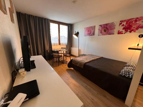 ヴァルベールにあるPlaza Valberg centre studio cabineのベッドとデスクが備わるホテルルームです。