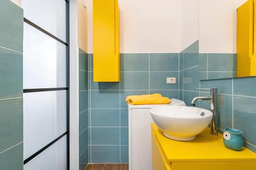 CASA DI SILVIA a PORTA PIA في روما: حمام مع حوض أبيض على منضدة صفراء