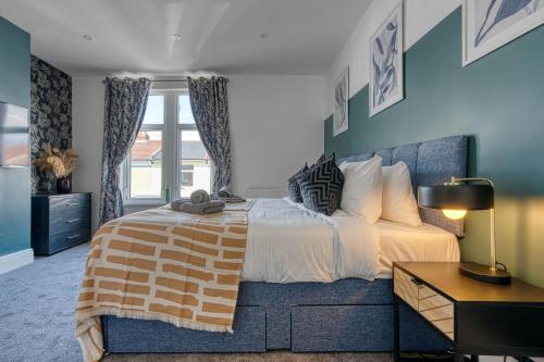 Un dormitorio con una cama grande y una ventana. en Stunning Design 3-Bedroom Townhouse Retreat in Southsea, Sleeps 8, Chic and Spacious with Free Parking Permit, WORK CONTRACTORS SPECIAL OFFER AVAILABLE! - by Blue Puffin Stays, en Portsmouth