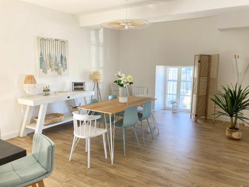 a living room with a dining room table and chairs at L'appartementducroisic - Sur le port, vue mer in Le Croisic