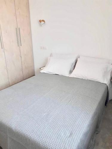 a white bed in a room with white walls at Seaside Serenade 2 suite in Ermoupoli