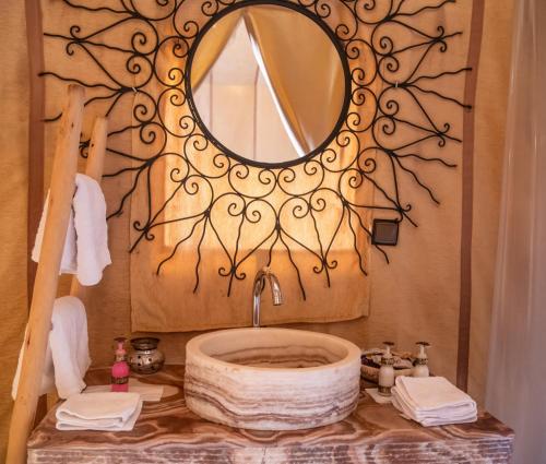a bathroom with a large mirror and a sink at Dihya desert camp in Merzouga