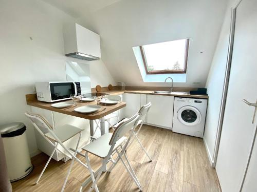 Welcome Home في Vert-le-Grand: مطبخ صغير مع طاولة وكراسي وميكروويف