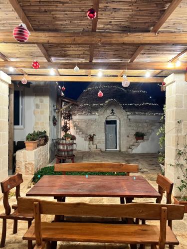 eine Terrasse mit einem Holztisch und Bänken in der Unterkunft Trulli bella vite in Putignano
