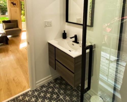 a bathroom with a sink and a mirror at Moose Cabin - Cozy Forest Retreat nearby Lake in East Kemptville