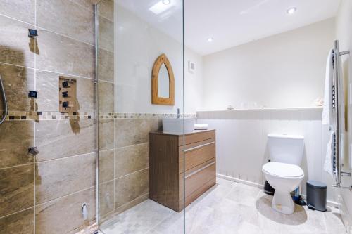La salle de bains est pourvue de toilettes et d'une douche en verre. dans l'établissement Stunning 4-bedroom Country House with Canal Views in Sandbach by HP Accommodation, à Sandbach