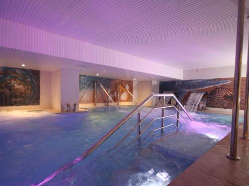 uma piscina num quarto grande com uma pintura em New Hotel Piscine Wellness & Spa em Casablanca