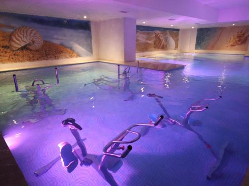 a large swimming pool with chairs in a room at New Hotel Piscine Wellness & Spa in Casablanca