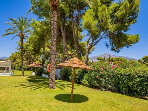 - un parc avec 2 palmiers et un parasol dans l'établissement Estudio Torre de Andalucía, à Marbella