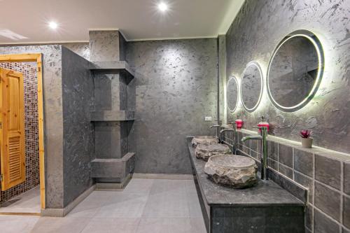 een badkamer met een stenen wastafel en 2 spiegels bij Bedcoin Hostel in Hurghada