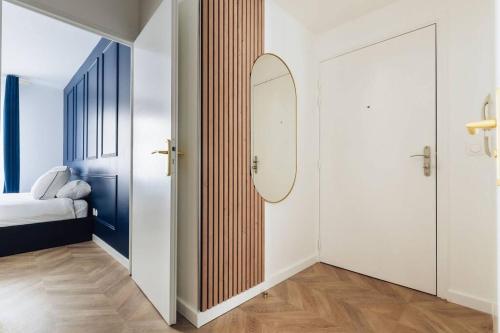 a hallway with a mirror and a bed in a room at Modernité près de Disneyland Paris in Serris