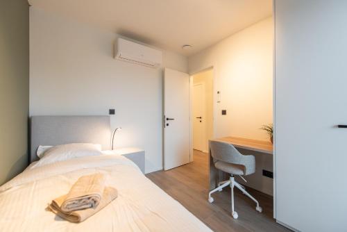 a bedroom with a bed and a desk and a chair at NIEUW De Grenspaal NOORD 6P - 3SLPK 5 min Maastricht - SAUNA - LAADPAAL in Riemst