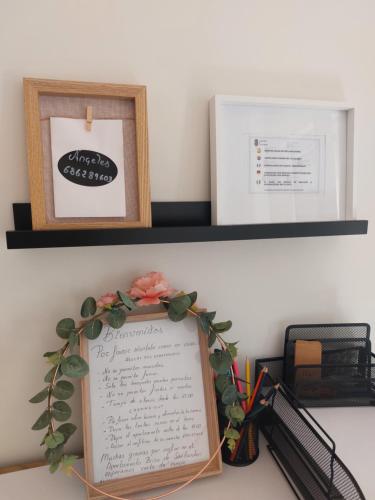 a shelf with two pictures and a sign on a desk at Apartamento Brisa de Santander in Santander