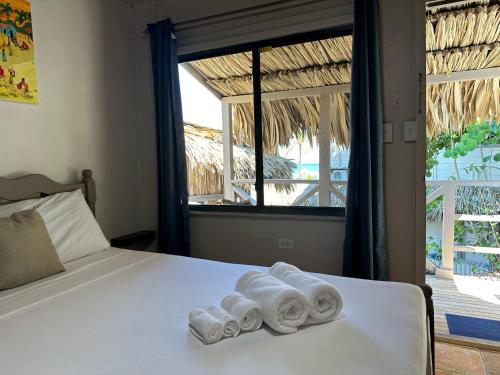 1 dormitorio con 1 cama con toallas en The Bounty, en Caye Caulker