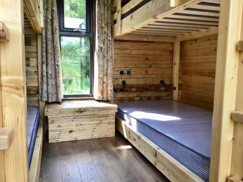 pokój z łóżkiem w drewnianym domku w obiekcie CEDAR CAMPING POD w mieście Great Ayton