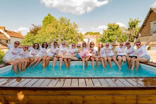 - un groupe de personnes en chemises blanches assises dans une piscine dans l'établissement Maison d'hôte privatisée avec piscine et jacuzzis 15 pers max, à La Couture-Boussey