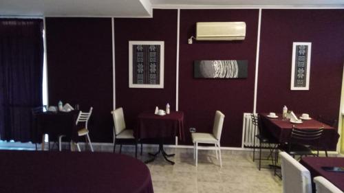een eetkamer met paarse muren en tafels en stoelen bij HOTEL CRONOS in Villa Carlos Paz