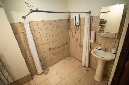 een badkamer met douche en wastafel bij Anona Guesthouse in Playa Hermosa