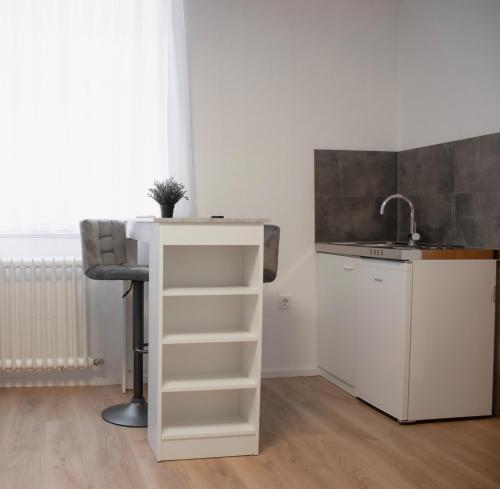 eine Küche mit einem Waschbecken, einem Tisch und einem Stuhl in der Unterkunft Modernes Apartment 3 in Bad Kreuznach mit einfachem Self-Check-in in Bad Kreuznach