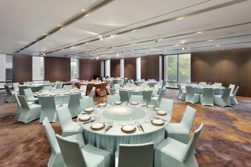 a large room with tables and white chairs and tablesearcher at Le Meridien Taipei in Taipei