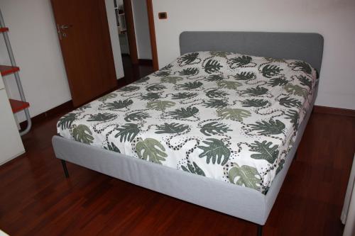 Bett in einem Zimmer mit einer weißen und grünen Decke in der Unterkunft Elegante appartamento trilocale in Mailand