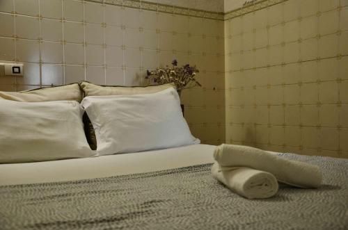 a bed with white pillows and a cat laying on it at RIA Terrace in Faro