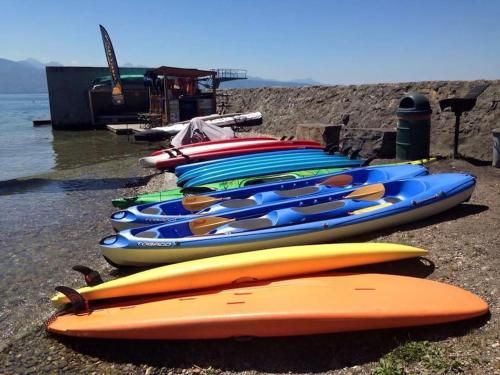 a group of kayaks lined up on the beach at L'Escale du Léman in Publier