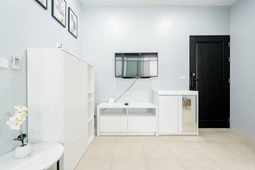 uma casa de banho branca com um lavatório e uma porta preta em Veloche Group em Ka Rorn