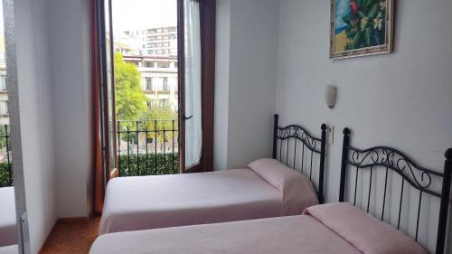 a bedroom with two beds and a window with a view at Pension Segura in Murcia