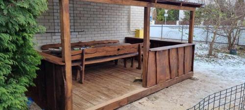 a wooden deck with a table and a bench at Town House in Kėdainiai