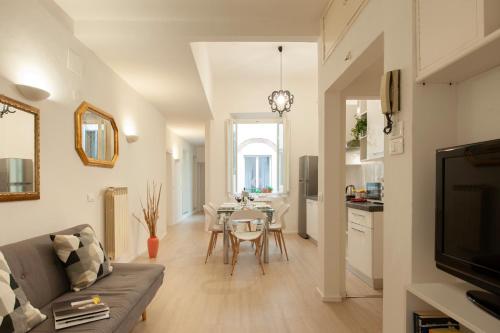 uma sala de estar com um sofá e uma mesa de jantar em Bargello - Flo Apartments em Florença