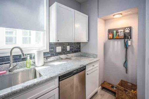 a kitchen with white cabinets and a sink and a window at Staying Comfortable in Central Columbus, Pet Friendly, 30 Day Min Stay in Columbus