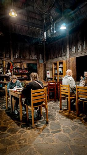 a group of people sitting at a table in a restaurant at Eco-Hotel Mayachik in San Juan La Laguna