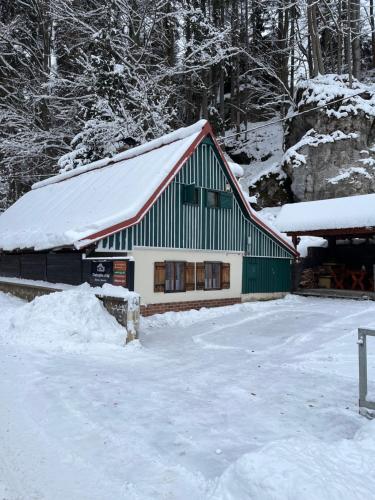 a green and white building in the snow at Chaloupka u Káji in Vítkovice