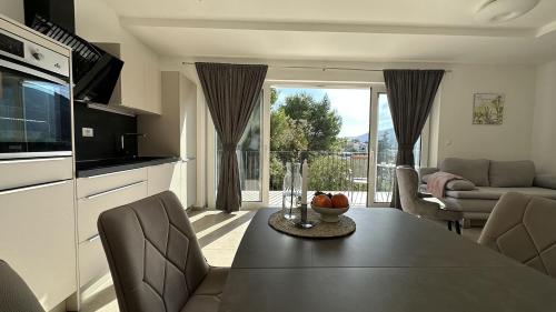a kitchen and living room with a table and a couch at Arte Oliva in Grebaštica