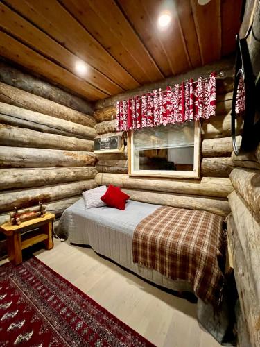 a bedroom with a bed in a log cabin at Villa Kelo in Rovaniemi